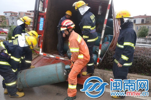 消防隊(duì)員將液化氣罐搬到另外一輛車上