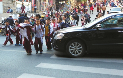 一輛汽車擠占了斑馬線，學(xué)生只能繞行