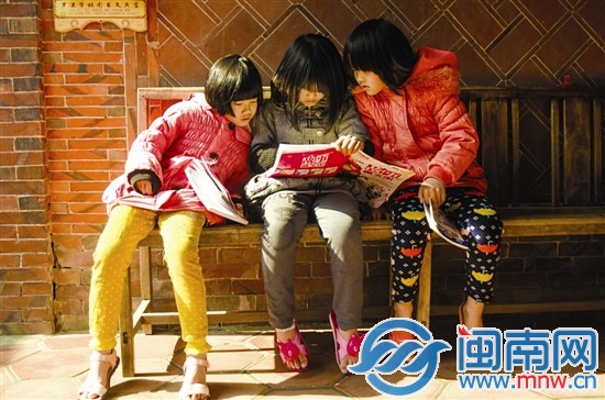 留守兒童收到捐贈(zèng)的書籍迫不及待地看起來