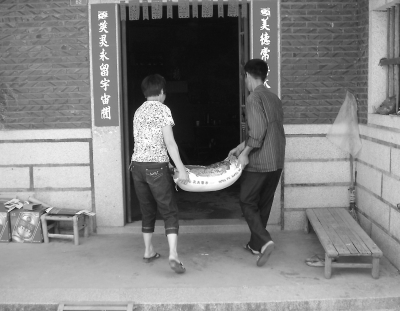 劉小川正在為鼎誠村的困難戶送米