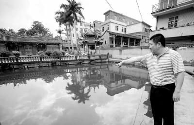 姚河水在孩子落水的池塘邊向記者回憶事情經(jīng)過。