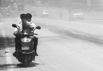 摩托車司機(jī)只能一手捂著口鼻，一手抓著扶手，快速闖