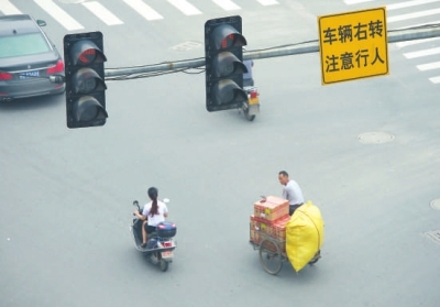 闖紅燈、不戴頭盔現(xiàn)象時(shí)有發(fā)生。本報(bào)記者陳明哲攝