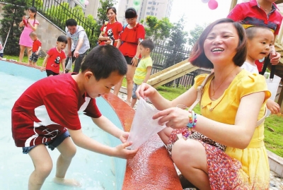 市第二幼兒園孩子與家長(zhǎng)一起玩抓泥鰍。