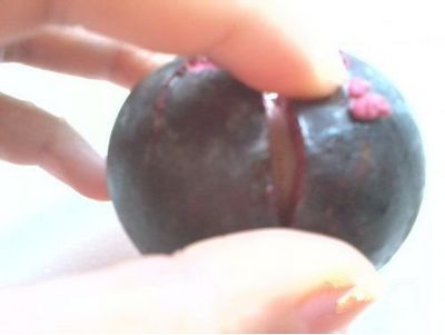 用菜刀，沿著其中兩瓣果肉的縫隙切下去