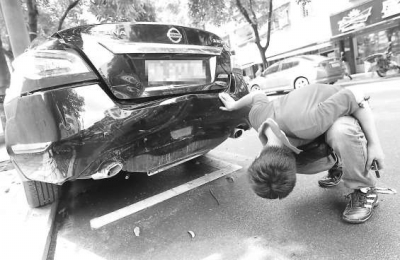 林先生查看受損的愛(ài)車。