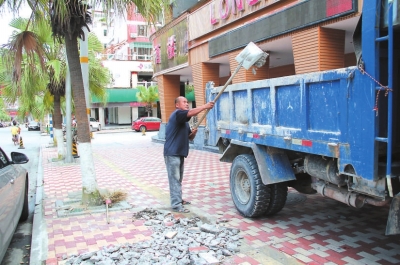 在市區(qū)長安街，工人正在清理路面修補(bǔ)后遺留下來的垃