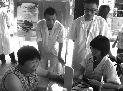 社會(huì)實(shí)踐活動(dòng)小組成員為黃碧蓮阿婆量血壓。