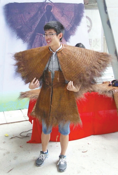 來賓興致勃勃地試穿陳奕培制作的蓑衣。