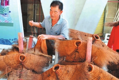 蓑衣制作傳承人詩(shī)山鎮(zhèn)鵬峰村的陳奕培在現(xiàn)場(chǎng)制作蓑衣。