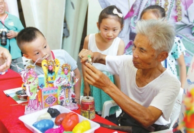 肖其昌在傳授小朋友妝糕人制作技藝。