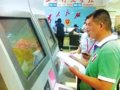 工作人員指導(dǎo)李建才在終端機(jī)上填寫材料。