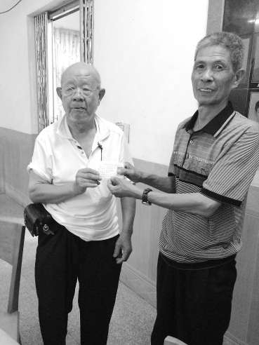 吳基揚（左）將辦好的證件遞交給村民。