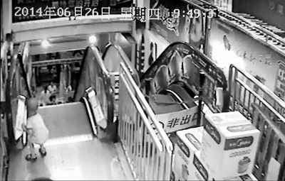 監(jiān)控顯示，白衣“熊孩子”按下電梯的緊急停止按鈕。