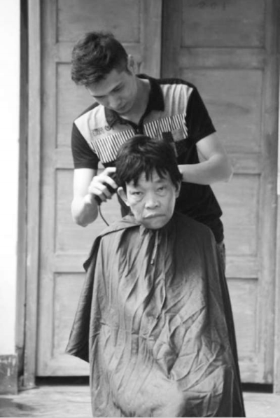 梁江華正在給老人理發(fā)。